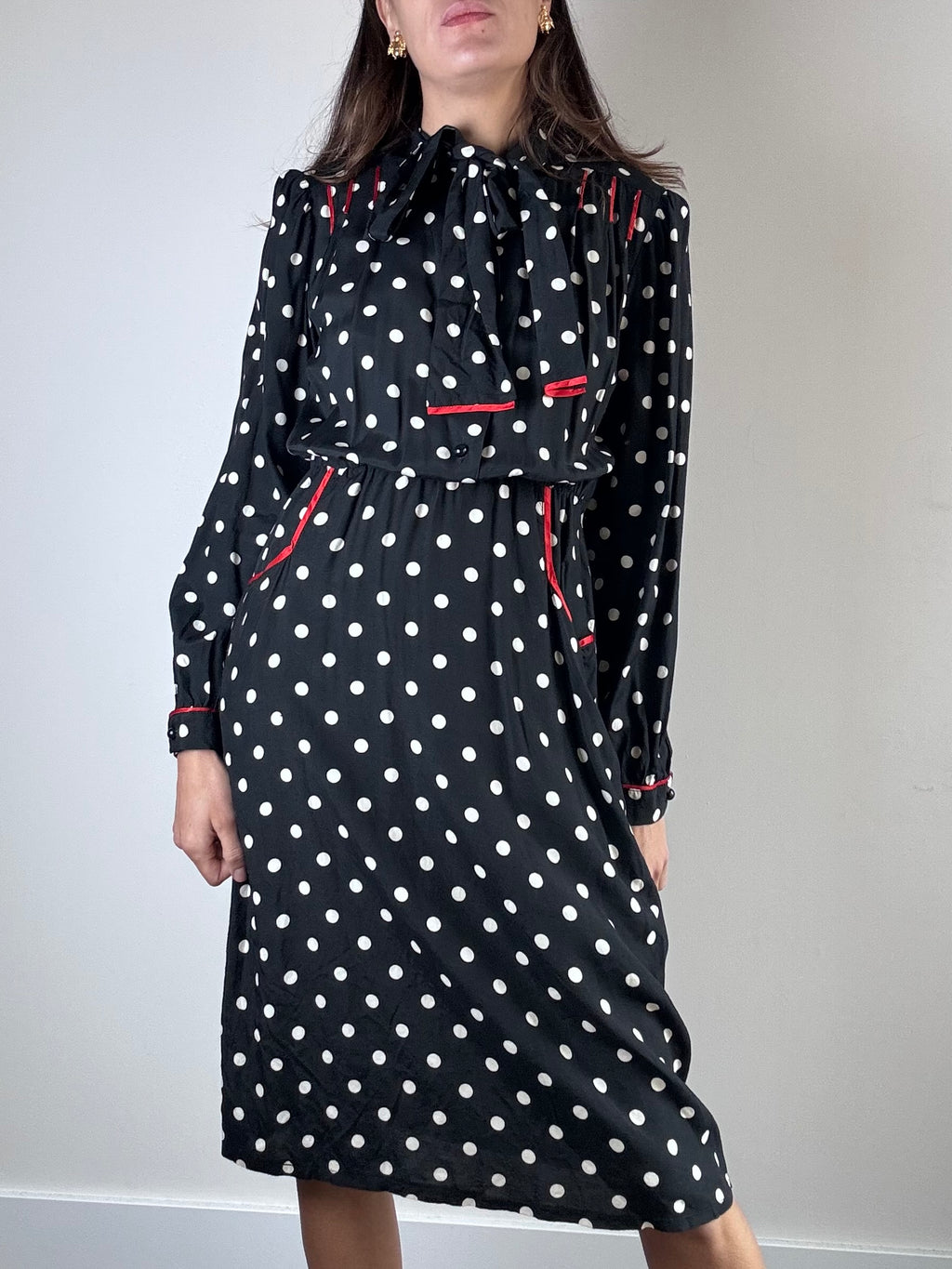 Abito nero a pois bianchi e profili rossi